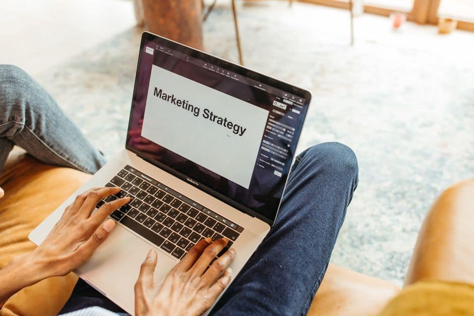 Responsable de marketing comprobando en un portátil qué respuestas aparecen ante preguntas reales de clientes